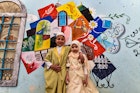 Children pose for a photo in front of a large graffiti depicting cultural elements including mosques, churches, old window lattices of the old town of Iraq's northern city of Mosul, on the first night of the Muslim holy fasting month of Ramadan on April 13, 2021, during a celebration hosted by a local cultural NGO. (Photo by Zaid AL-OBEIDI / AFP) (Photo by ZAID AL-OBEIDI/AFP via Getty Images)